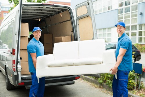 Furniture pick-up service removing a sofa in Belsizepark