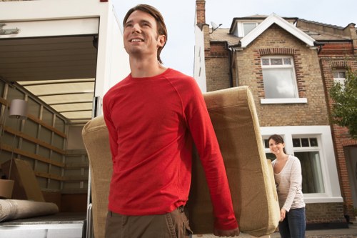Local moving professionals handling furniture in a narrow Belsize Park street
