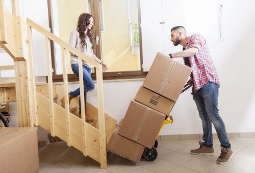 House removalists carefully carrying furniture through a residential property in Belsizepark